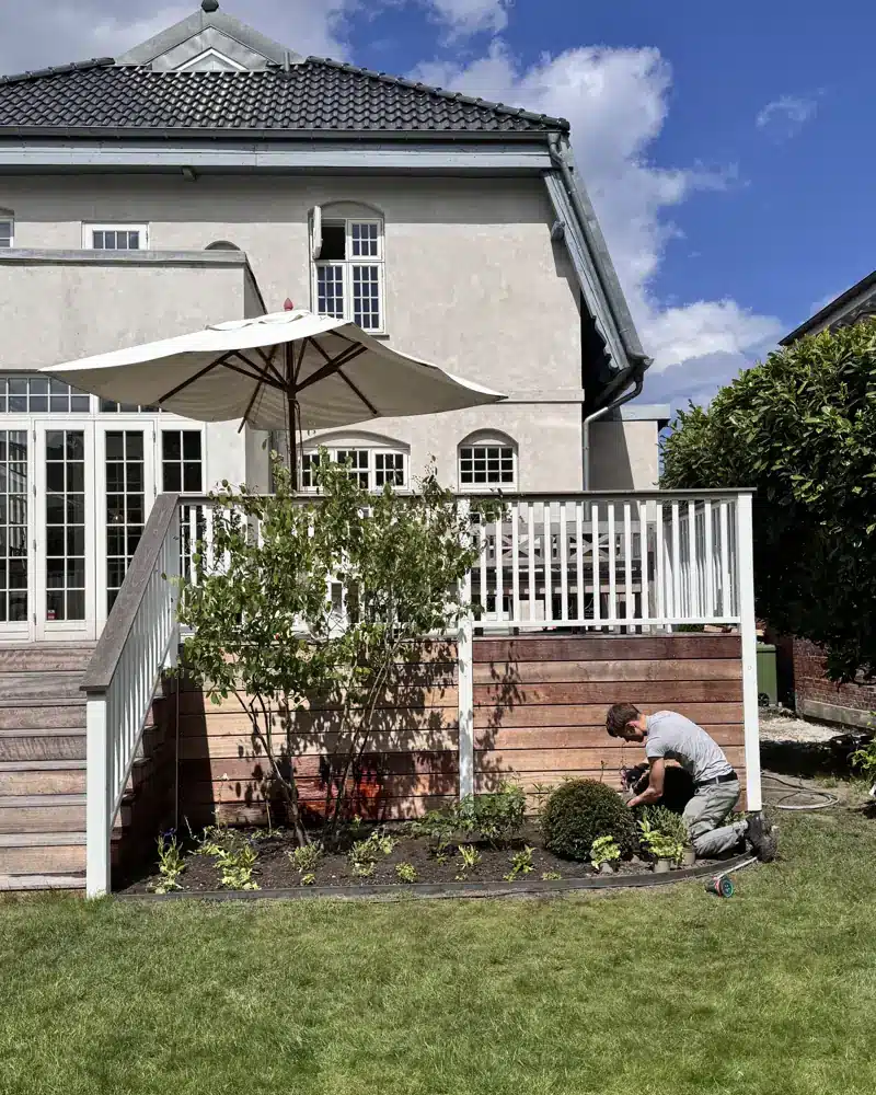 Seamus Hall planter buske ved en terrasse.